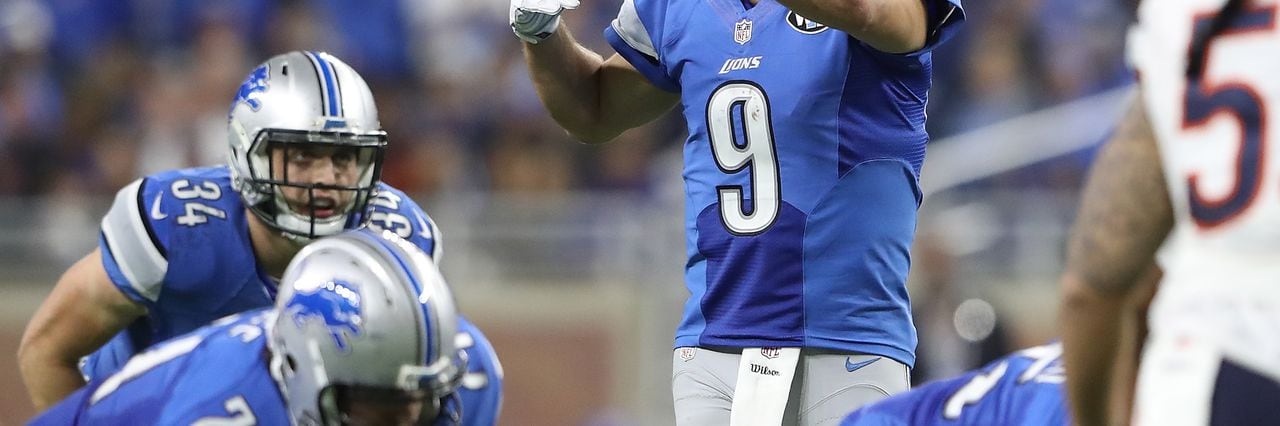 Georgia quarterback Matthew Stafford holds up his Detroit Lions